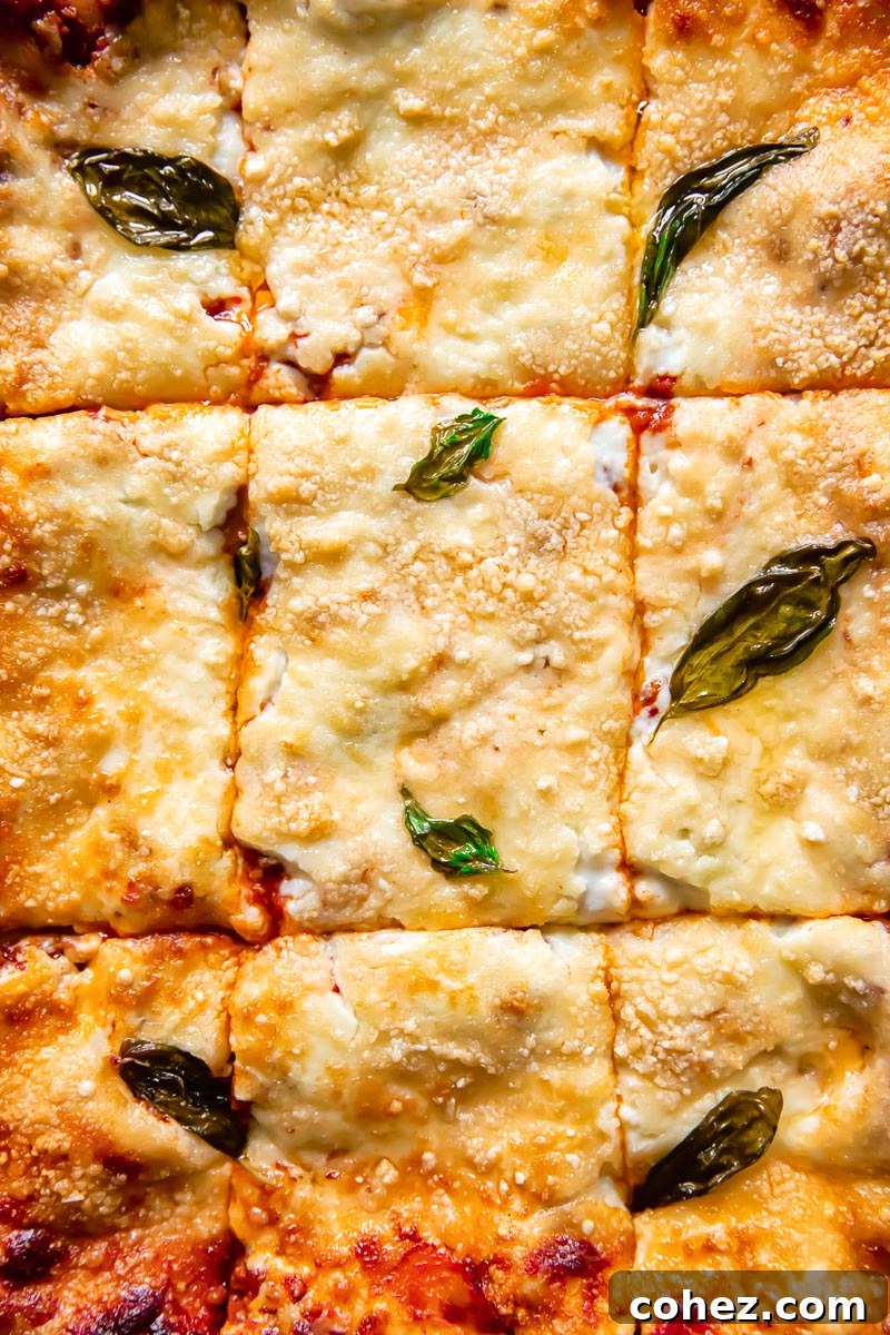 a close-up shot of a classic lasagne portion cut into squares, showing golden-brown top and bubbling cheese