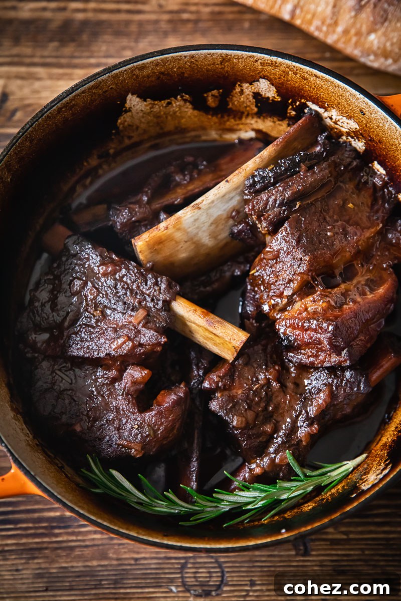 short ribs simmering in braising liquid in a cast iron pot