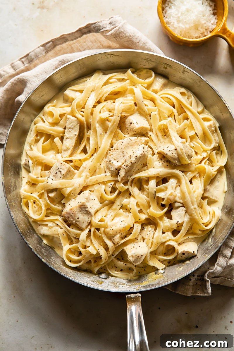 Top-down view of creamy chicken pasta in a pan, ready to be served.