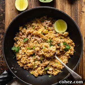 top down view of fried rice in a wok, a green bowl with greens and a green bowl with sliced red chilli next to the wok