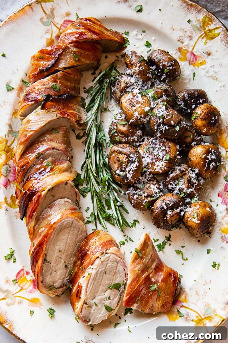 Roasted pork tenderloin served on a platter with pan-fried mushrooms, highlighting its golden-brown crust