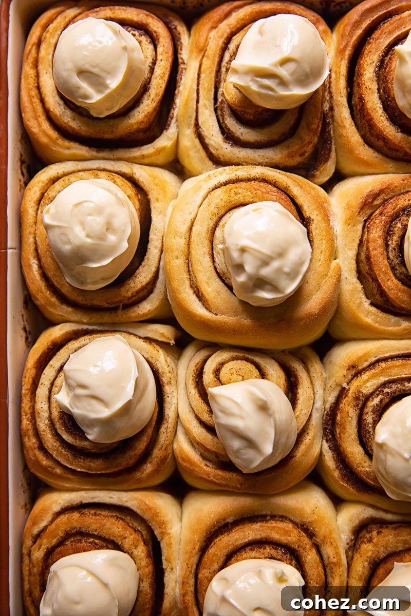 Decadent Cinnamon Buns with Maple Cream Cheese Frosting 4 cinnamon rolls with dollops of icing on top