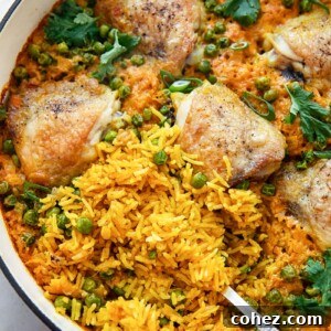 top down view of chicken thigh and yellow turmeric rice casserole with green peas