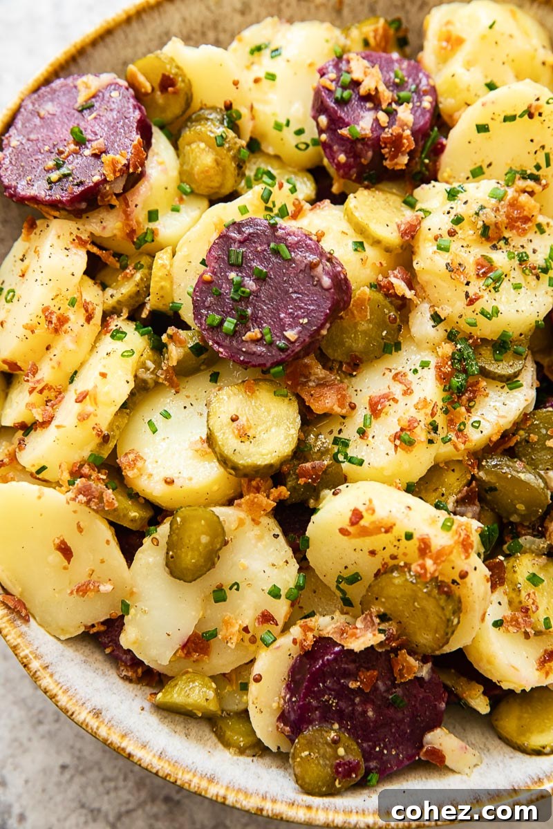 close up of potato salad with pickles and bacon