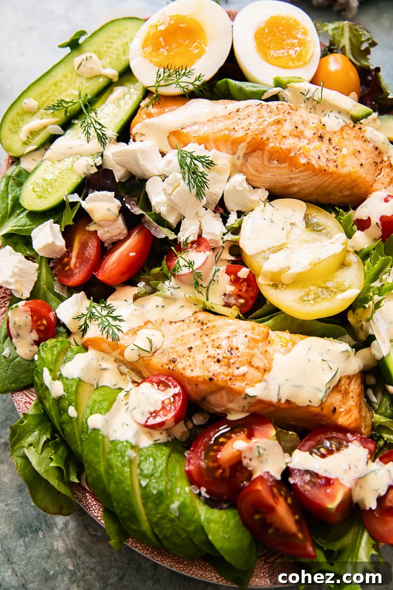 Vibrant Salmon Cobb Salad featuring flaky lemon-pepper salmon, creamy avocado, perfectly boiled eggs, and a light lemon-dill dressing, served on a bed of fresh greens.