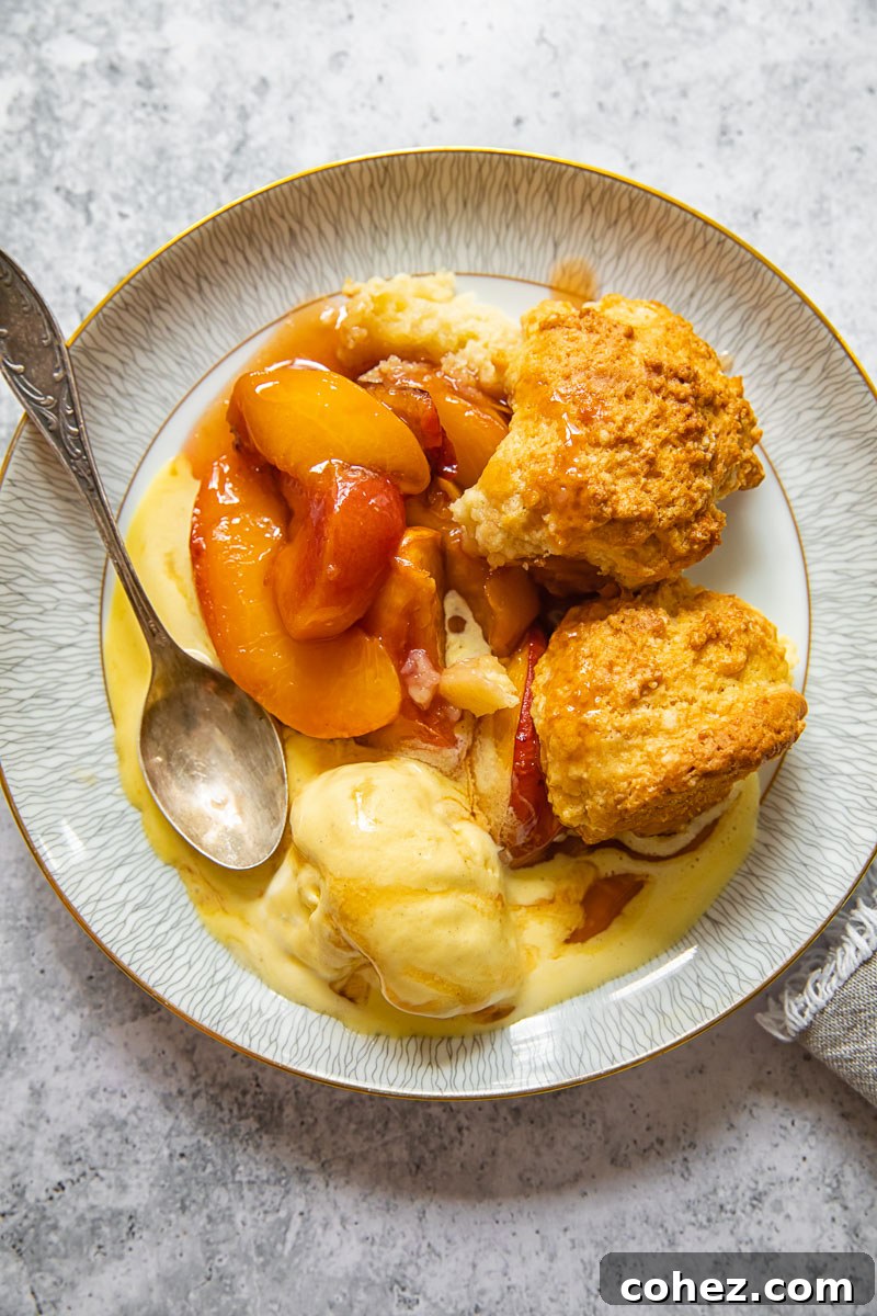 Golden Maple Peach Cobbler 3 peach dessert on a plate with a spoon