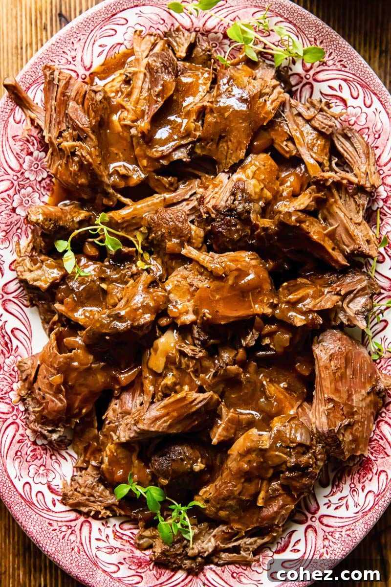 shredded lamb on a platter with gravy on top