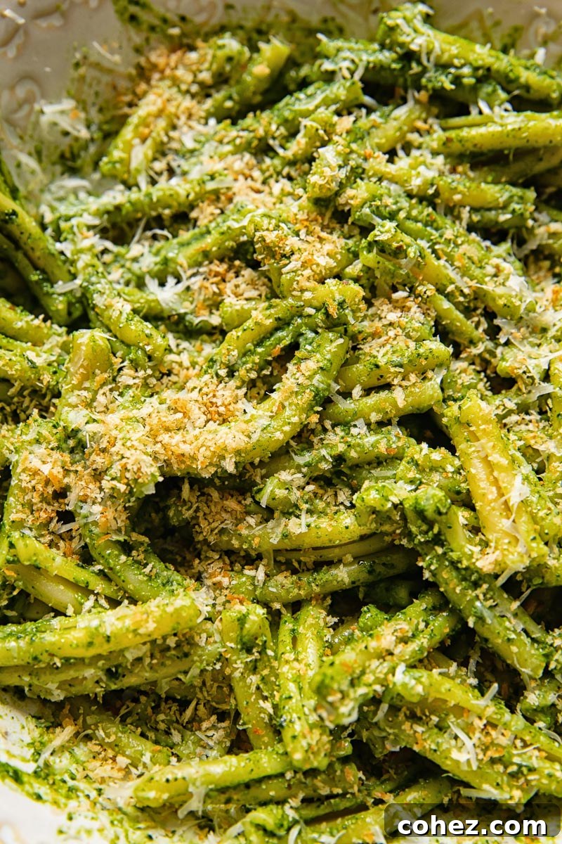 close up of pesto pasta covered with breadcrumbs