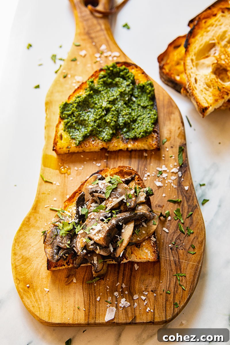 Close-up view of perfectly arranged mushroom crostini on a rustic wooden board, garnished with fresh parsley.