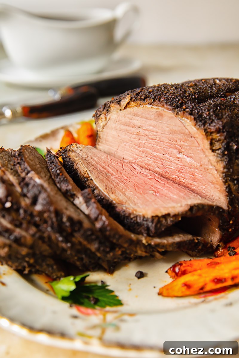 Side view of perfectly sliced roast beef on a platter, showcasing its pink, juicy interior.