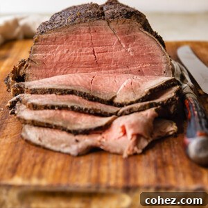 Slices of roast beef and whole beef joint on cutting board