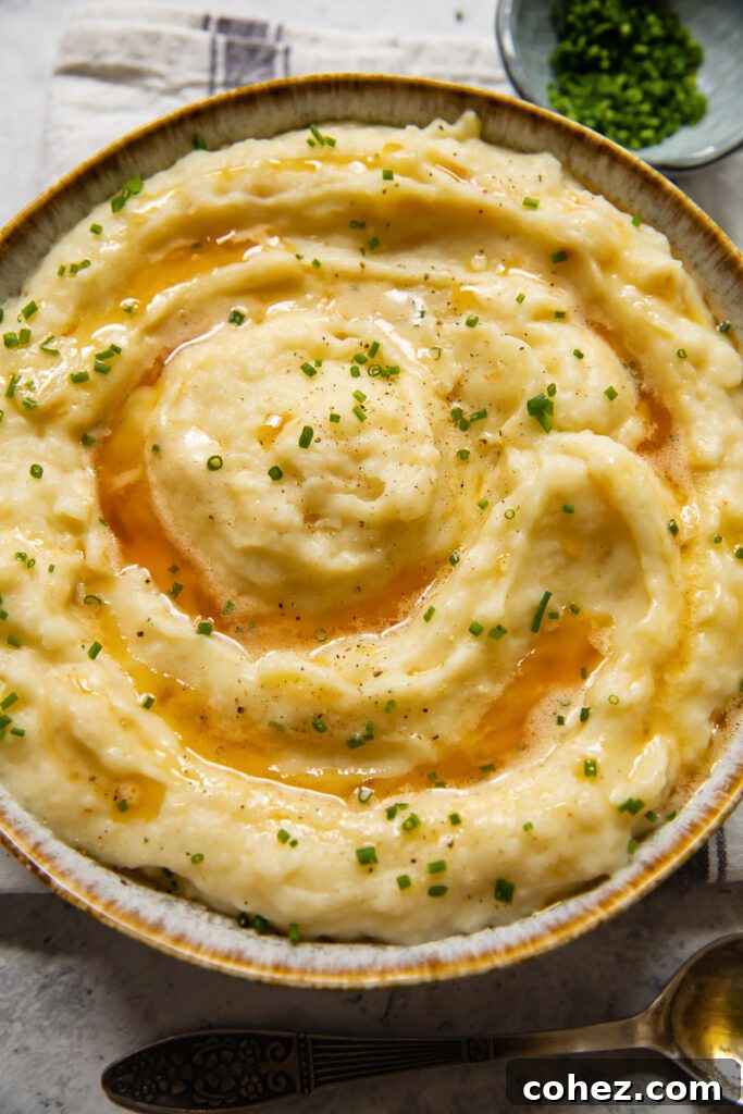 A beautifully presented bowl of creamy celeriac and potato mash, garnished with fresh herbs, ready to be served as a sophisticated side dish.