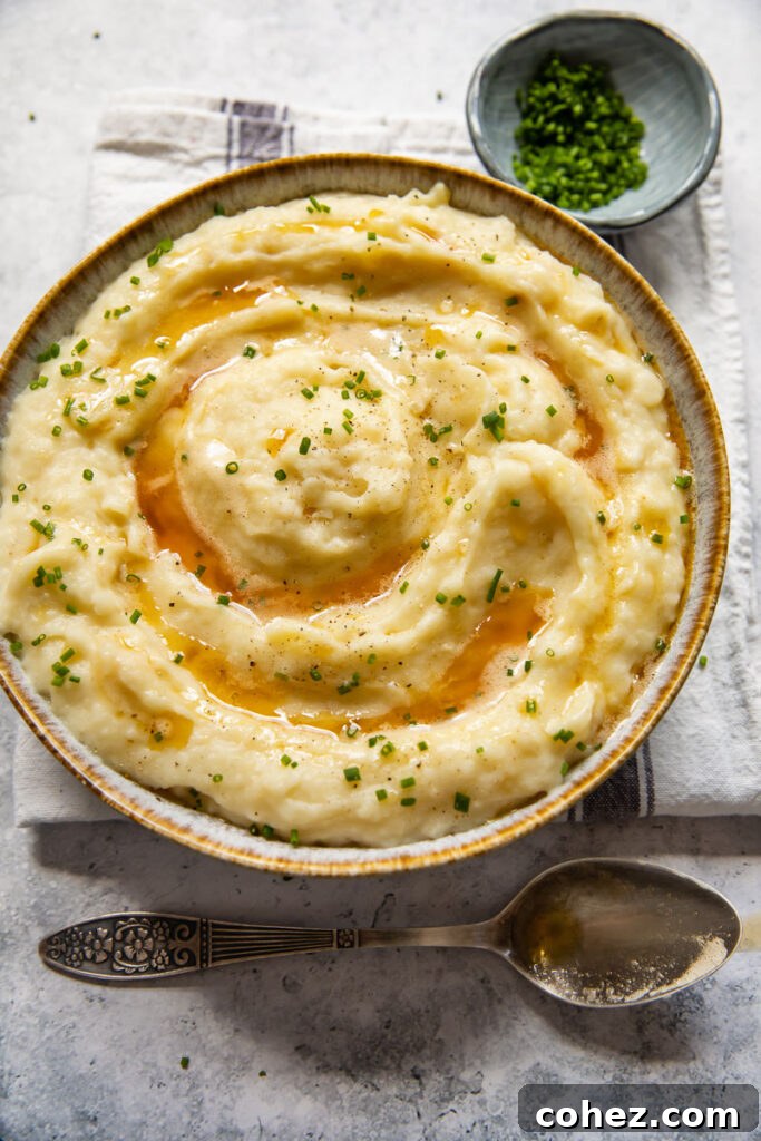 An overhead view of the finished creamy celeriac and potato mash, served in a rustic bowl, garnished with fresh chives, inviting a delicious meal.