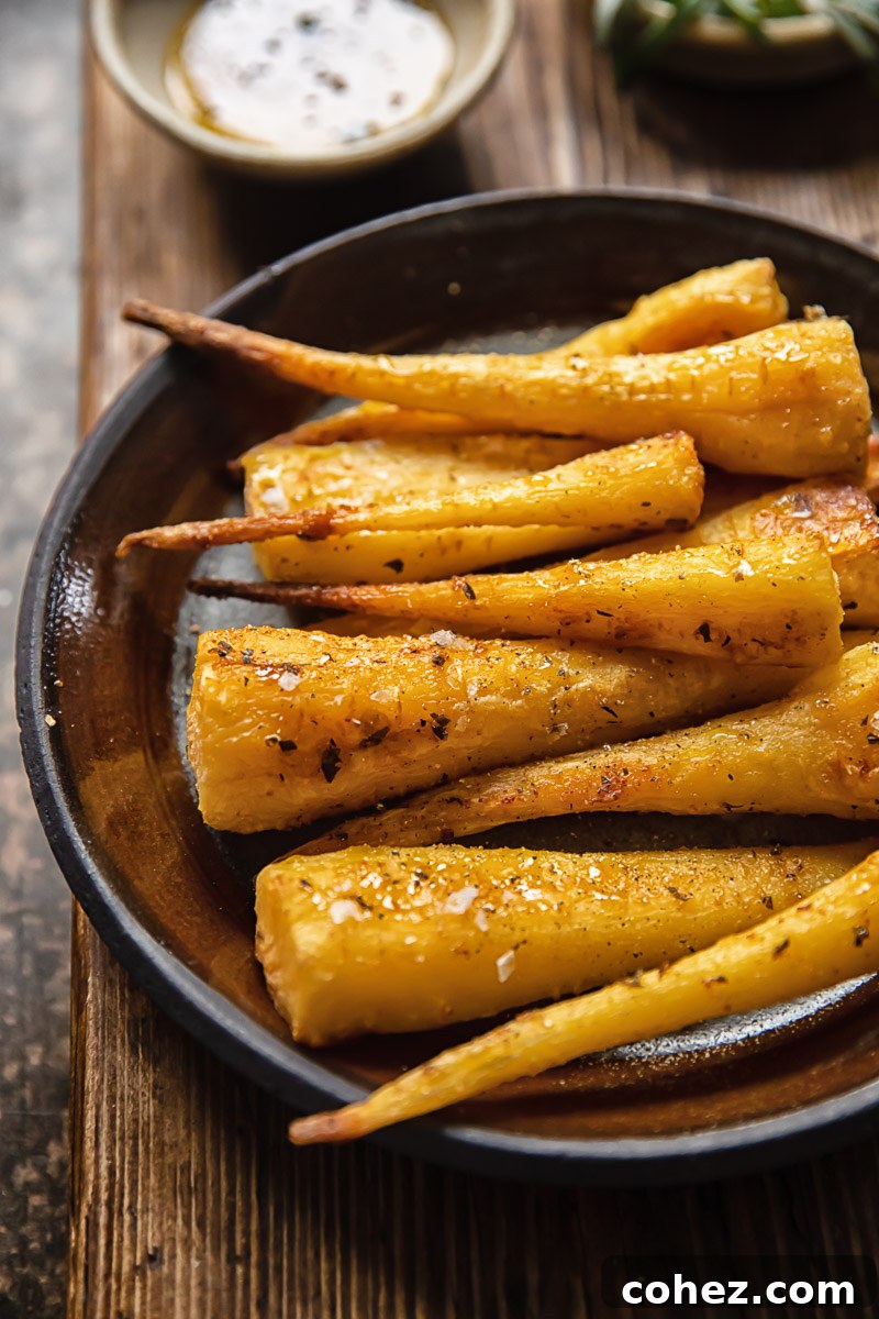 Perfectly roasted parsnips with honey and garlic glaze on a brown plate, ready to serve.