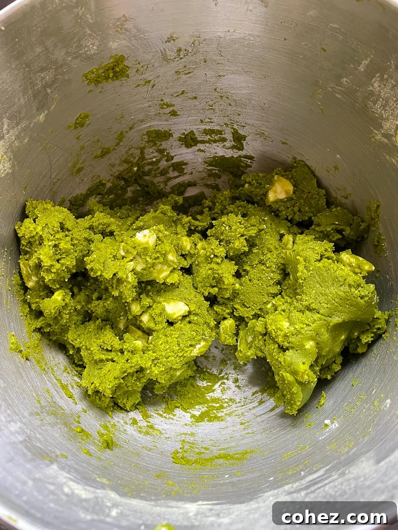 Close-up of vibrant green cookie dough studded with white chocolate chunks