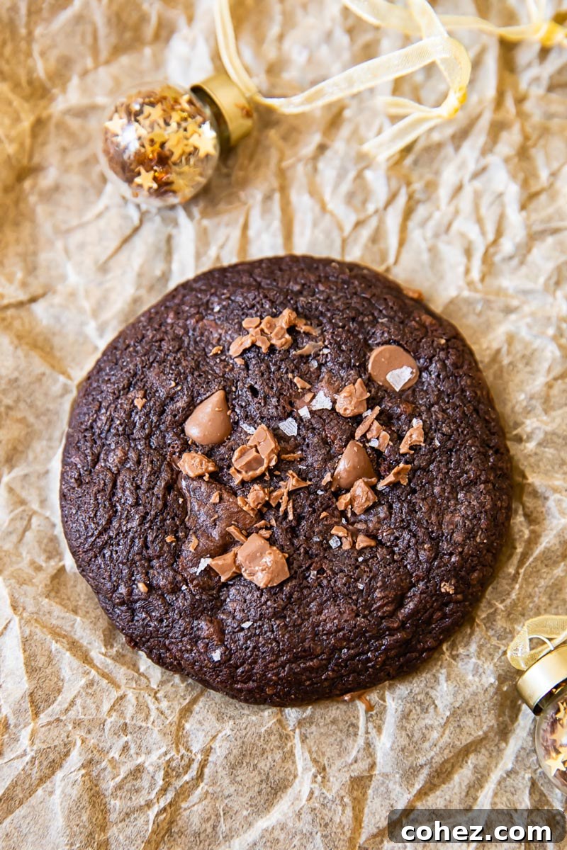 top down view of a chocolate cookie with mint chocolate chunks and a mini Christmas tree ornament