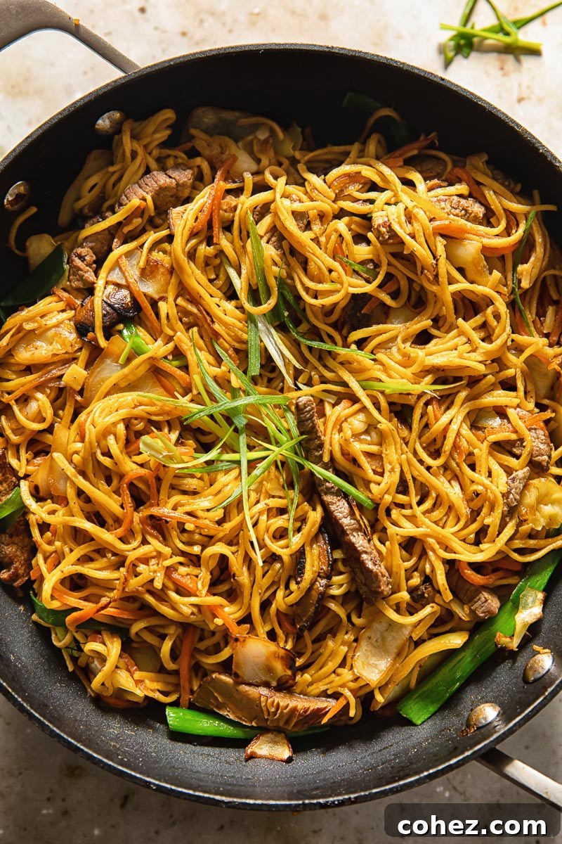 Yakisoba noodles and ingredients being expertly tossed in a wok during the cooking process.