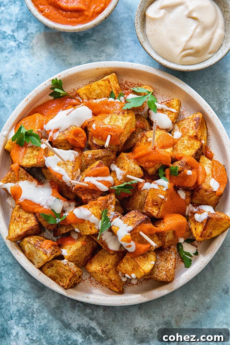 top down view of patatas bravas with the red sauce and alioli