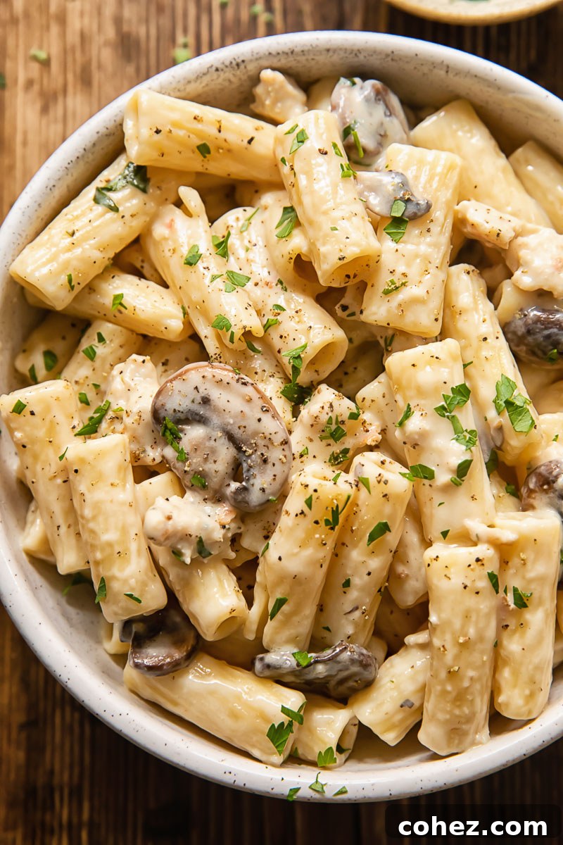 Hearty Italian Sausage and Mushroom Pasta 2 A steaming bowl of creamy Italian sausage pasta with mushrooms, garnished with fresh parsley.