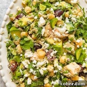 Plant-Powered Tuna Salad 6 Top down view of a vibrant Chickpea Tuna Salad on an oval platter, showcasing fresh ingredients like chickpeas, tuna, cucumber, avocado, and feta.