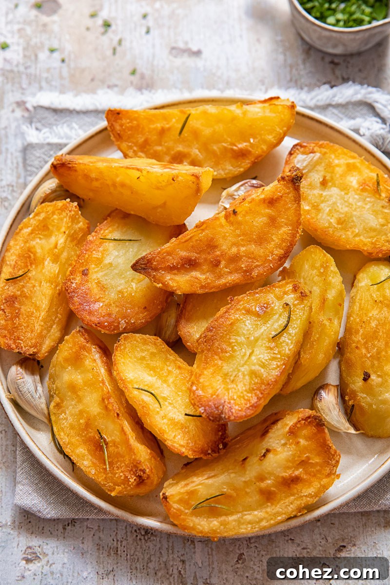 Top down view of golden roast potatoes on a plate.