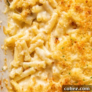 Close-up of baked truffle mac and cheese in a ceramic dish, showing a golden-brown crispy topping and bubbling cheese sauce