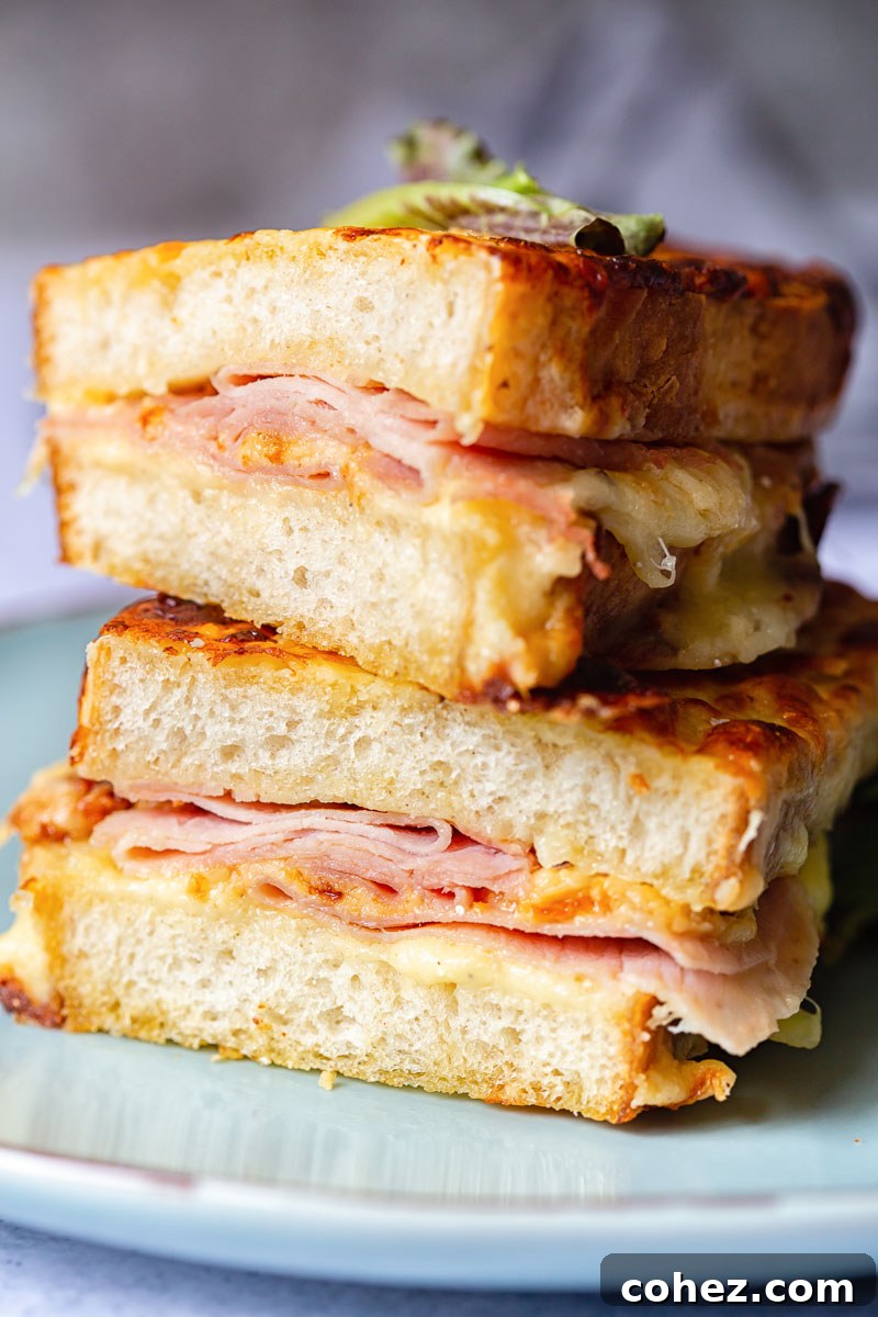 Two halves of a delicious Croque Monsieur, stacked on a plate ready to be enjoyed.