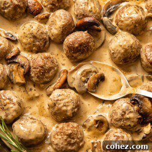 Top down view of spoon scooping meatballs in Marsala sauce from a pan