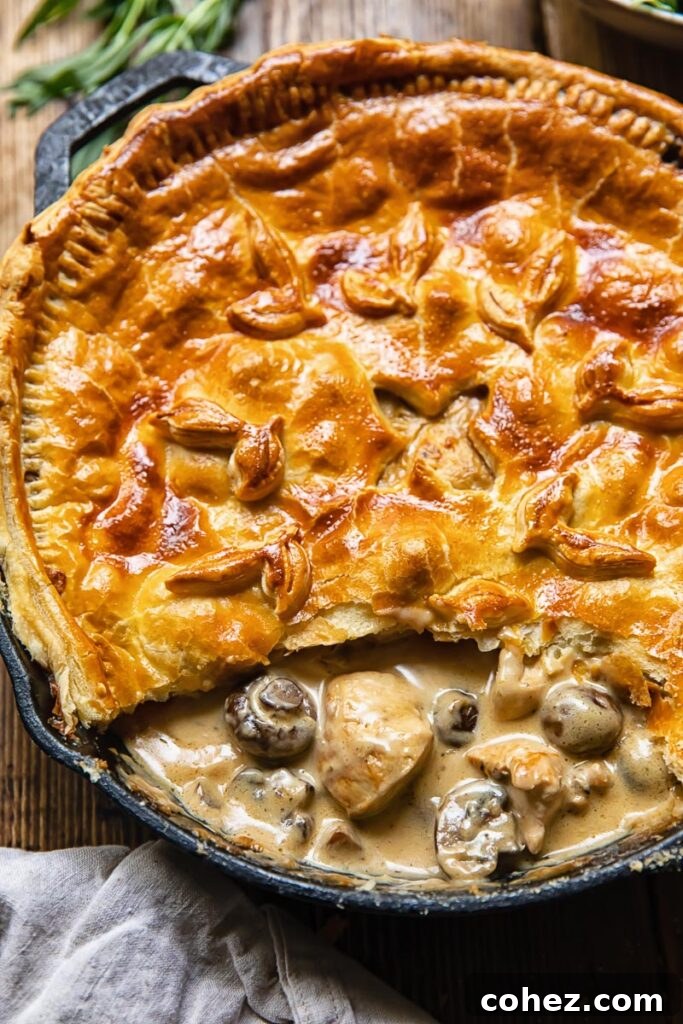 A delicious chicken and mushroom pie with one slice removed, showcasing its creamy interior.