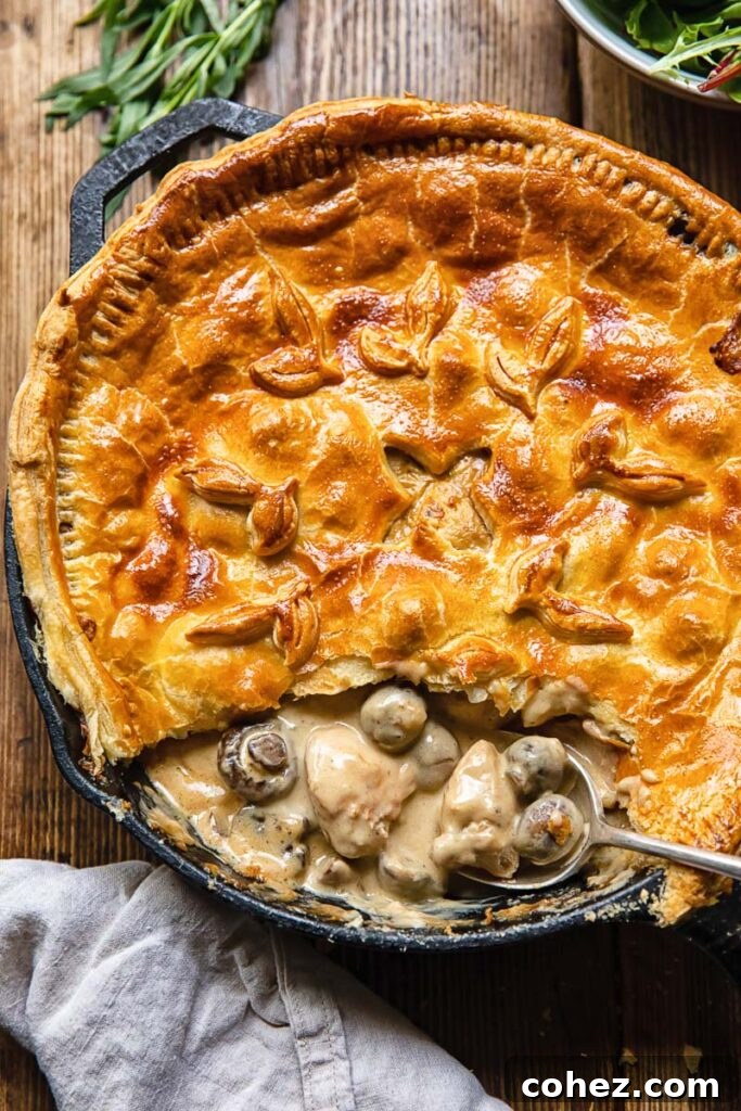A slice of chicken and mushroom pie, showing the tender chicken and creamy mushroom filling.