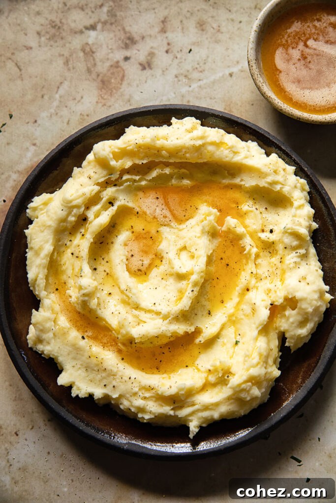 Top down of a plate of mashed potatoes, showcasing its rich, creamy texture and subtle golden hue from brown butter.