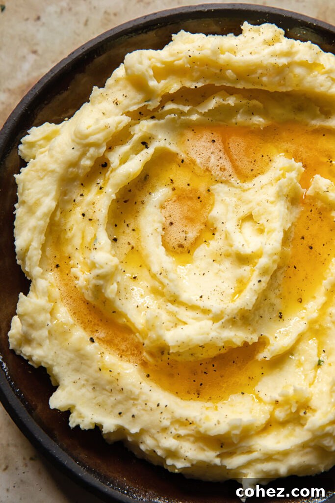 Close up of mashed potatoes with a swirl of brown butter on top, highlighting the creamy texture and inviting presentation.