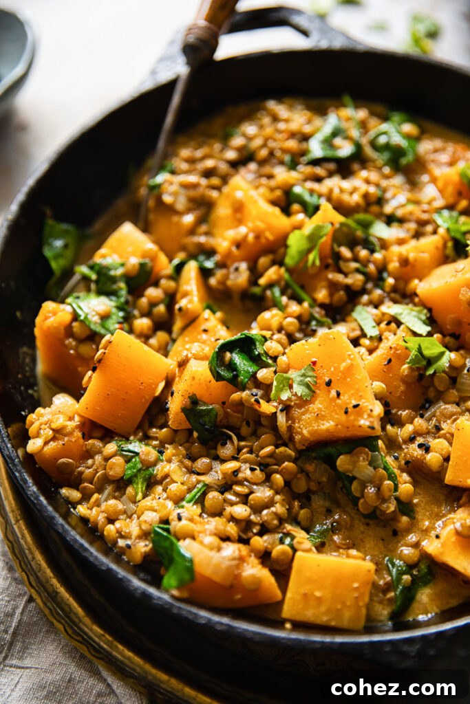 Vibrant Coconut Lentil Curry with Butternut Squash cooking in a large pan, ready to serve
