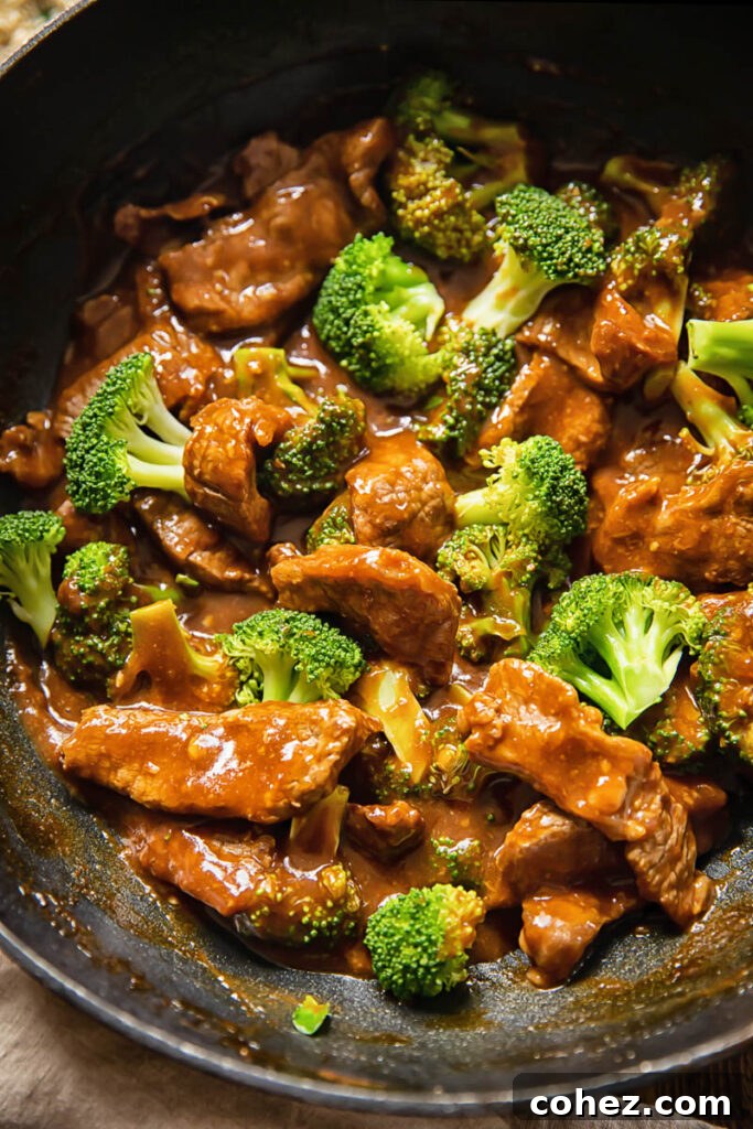 wok with beef and broccoli stir fry, glistening with sauce and ready to be served