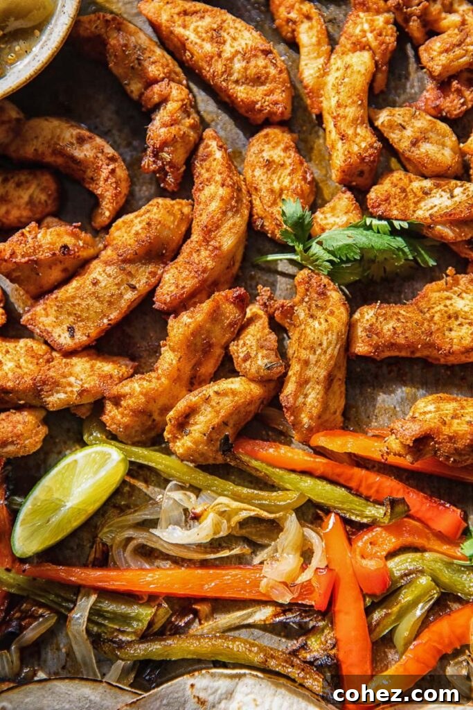 Close-up of perfectly cooked chicken strips and vibrant bell peppers, ready to be assembled into delicious fajitas, with fresh lime and cilantro garnish.
