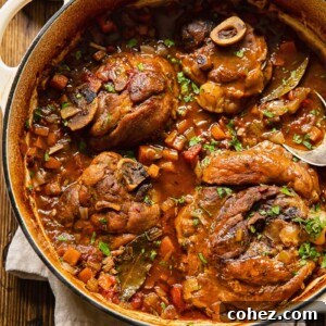 Pork osso buco in a pot with cut up carrots and celery