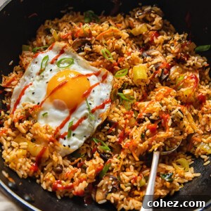 A vibrant wok filled with golden Kimchi Fried Rice, topped with a perfectly fried egg, ready to be served.