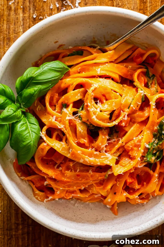 Close-up of strands of tagliatelle pasta generously coated in creamy tomato mascarpone sauce