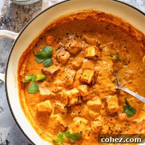 large pan of paneer tikka masala beside bowl of cilantro