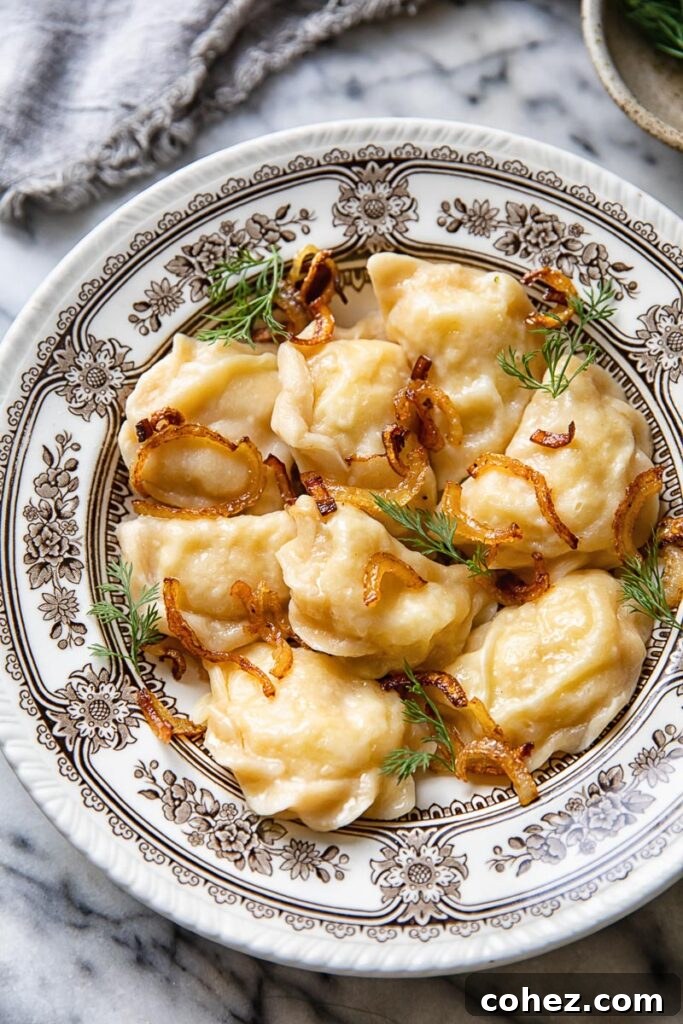 A bowl of golden potato vareniki topped with sautéed onions and fresh dill, ready to be enjoyed.