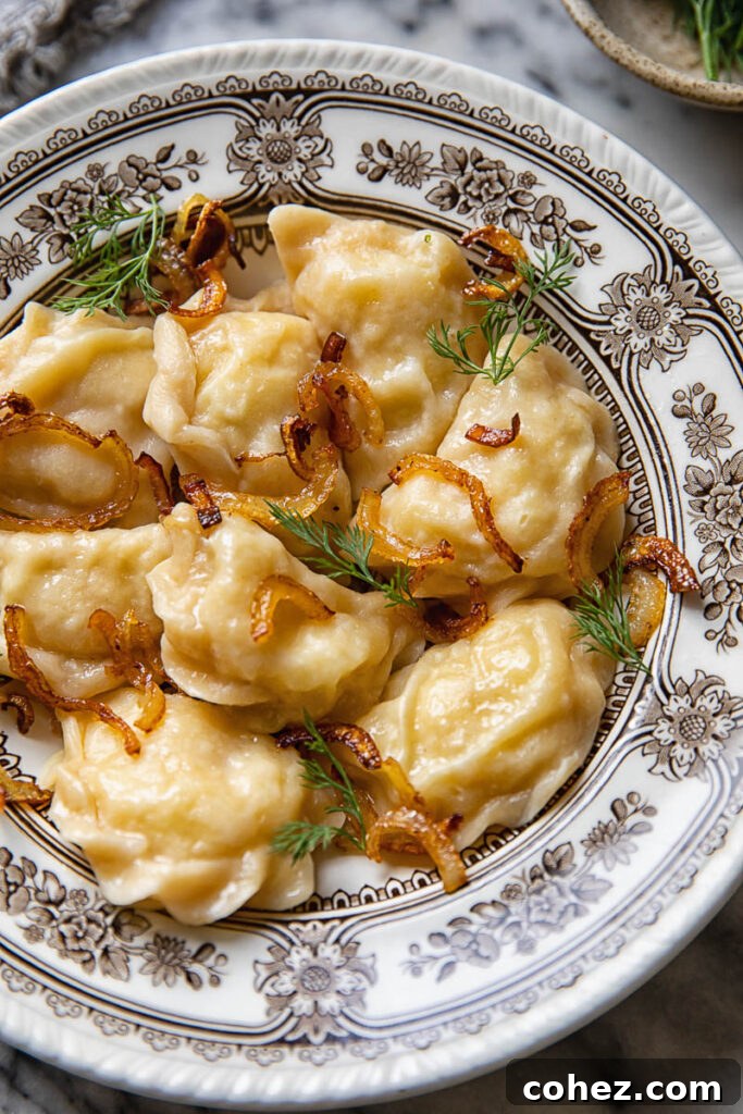 A plate of golden-brown potato Pierogi served with sautéed onions and fresh dill.