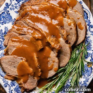 Fall Apart Slow Cooker Roast 6 Top down shot of slow cooker roast beef on a plate with gravy and rosemary