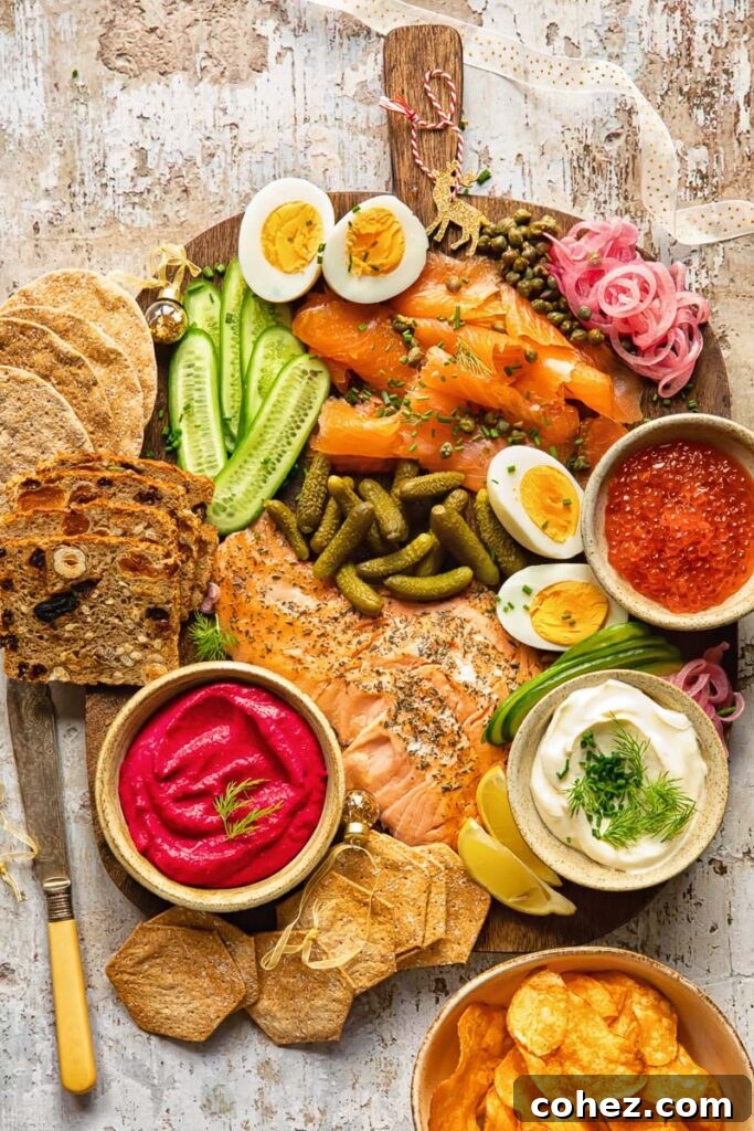Nordic Gathering Board 2 Top down view of a Scandi-inspired grazing board featuring smoked salmon, cucumbers, pickles, capers, and various dips and crackers, beautifully arranged for a festive occasion.