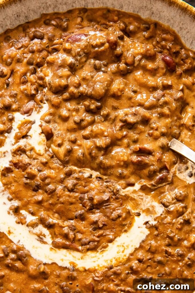 A close-up of the rich, creamy Dal Makhani, showing its luxurious texture and the delicate swirl of cream on top.