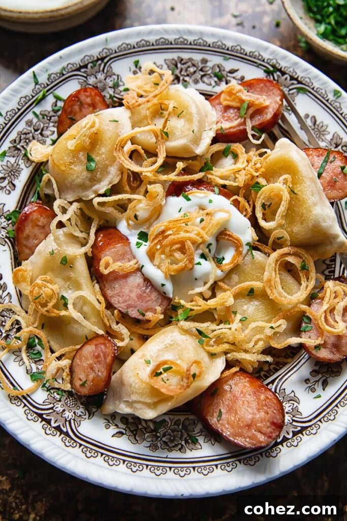 Bowl of pierogies and sliced kielbasa topped with crispy caramelised onions