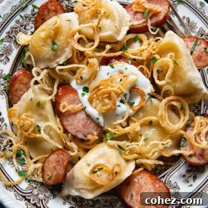 Bowl of pierogies and sliced kielbasa topped with crispy caramelised onions