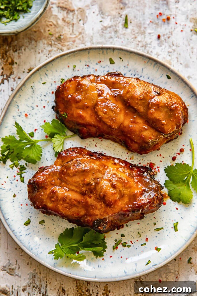 Close up shot of two glazed, boneless pork chops on a plate