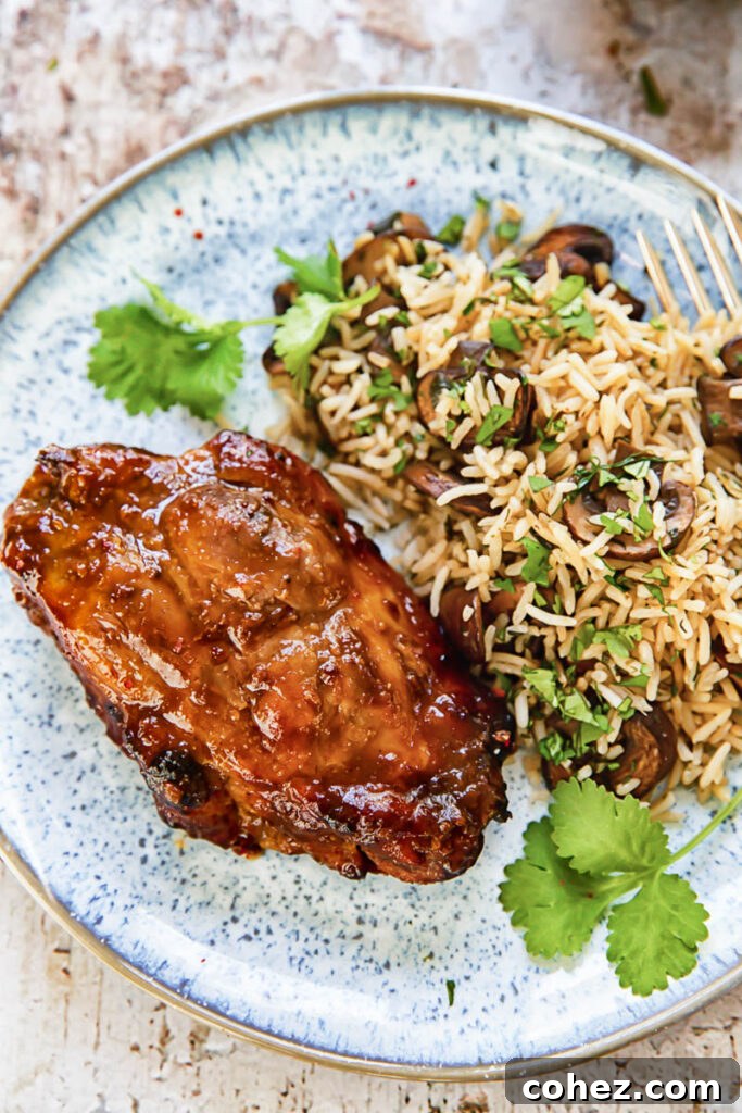 Top down view of a boneless pork chop on a plate next to herbed rice