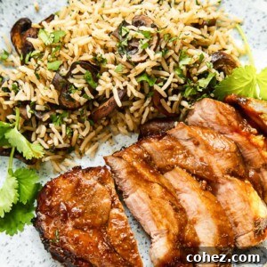 Top down view of boneless pork chop slices on a plate with herbed mushroom rice