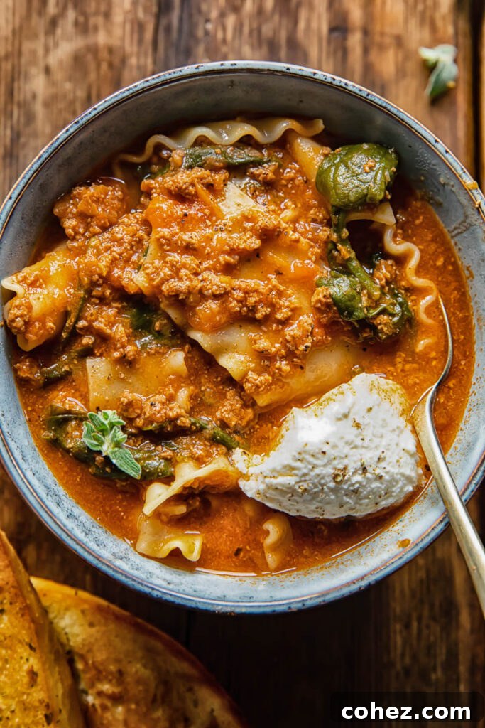 bowl of lasagna soup with dollop of sour cream and a spoon